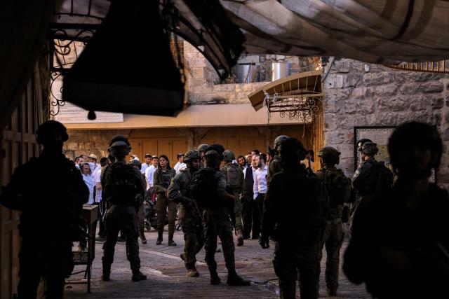 Israeli security forces stand guard as Israeli settlers tour in the Palestinian side of the old city and market of Hebron in the occupied West Bank on July 5, 2025. (Photo by HAZEM BADER / AFP)