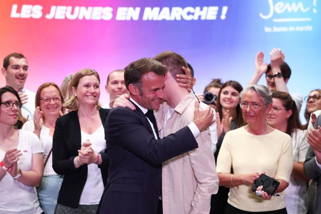France's President Emmanuel and President of "Les Jeunes avec Macron" Ambroise Mejean embrace during a rally marking the 10th anniversary of "Les Jeunes avec Macron" (Youth with Macron), the youth movement of the Renaissance party, at the Cirque d'Hiver in Paris on July 5, 2025. (Photo by Sebastien DUPUY / AFP)