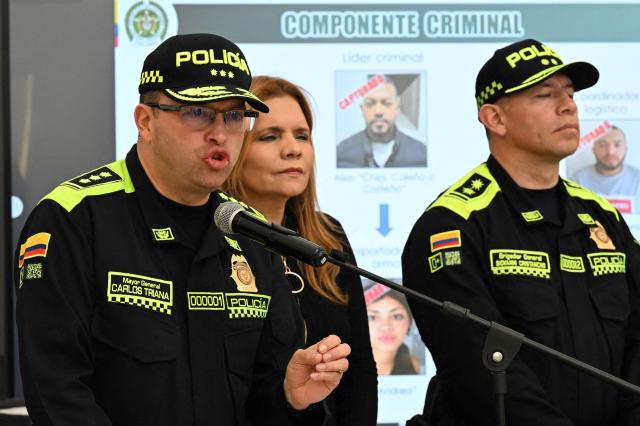 Colombia's Police Director, Carlos Triana, speaks in front of a projected image of Elder Jose Arteaga Hernandez, the suspect in the attack on Colombian presidential candidate Miguel Uribe, during a press conference in Bogota on July 5, 2025. Uribe, a 39-year-old conservative senator, was shot twice in the head and once in the leg by a 15-year-old suspected hitman while giving a campaign speech on June 7. (Photo by Luis ACOSTA / AFP)