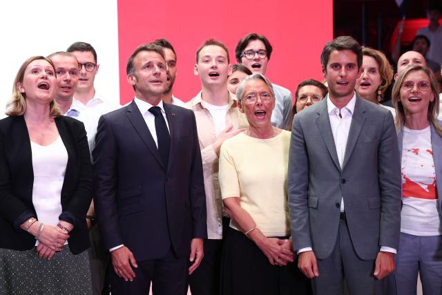 France's President Emmanuel (2L) sings the National Anthem of France (La Marseillaise) with President of the French National Assembly Yael Braun-Pivet (L), President of "Les Jeunes avec Macron" Ambroise Mejean (3L), France's Minister of Education, Higher Education and Research Elisabeth Borne (C), President of Ensemble Pour la Republique parliamentary group Gabriel Attal (2R) and France's Minister of Minister of Ecological Transition, Biodiversity, Forest, Sea and Fisheries Agnes Pannier-Runacher  during a rally marking the 10th anniversary of "Les Jeunes avec Macron" (Youth with Macron), the youth movement of the Renaissance party, at the Cirque d'Hiver in Paris on July 5, 2025. (Photo by Sebastien DUPUY / AFP)