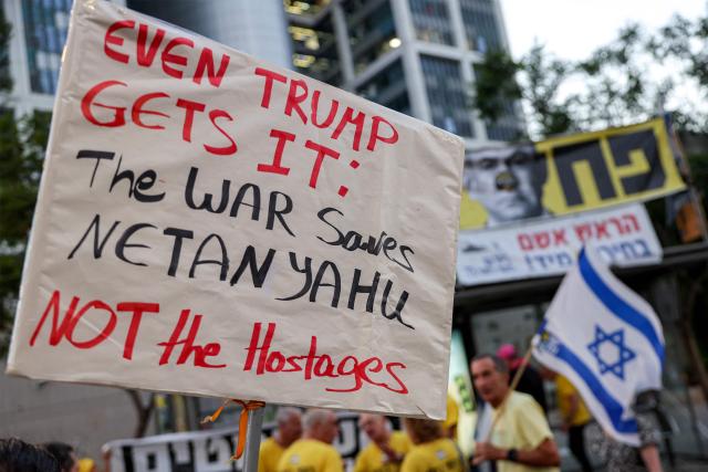 A demonstrator poses with a placard during an anti-government protest calling for action to secure the release of Israeli hostages held captive in the Gaza Strip by Palestinian militants since the 2023 October 7 attacks, outside the Israeli Defence Ministry headquarters in Tel Aviv on July 5, 2025. (Photo by Jack GUEZ / AFP)