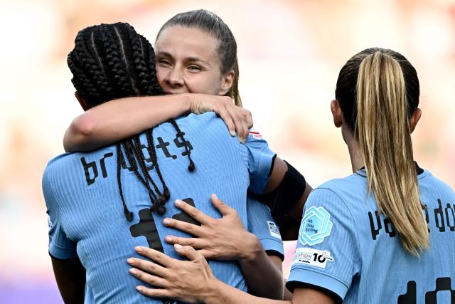 Netherlands' forward #11 Esmee Brugts is hugged by Netherlands' midfielder #17 Victoria Pelova (2ndr) as she celebrates scoring the team's third goal during the UEFA Women's Euro 2025 Group D football match between Wales and The Netherlands at the Allmend Stadion Luzern in Lucerne on July 5, 2025. (Photo by Fabrice COFFRINI / AFP)