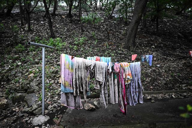 Towels and clothing hang on a clothesline outside of a cabin at Camp Mystic, the site of where at least 20 girls went missing after flash flooding in Hunt, Texas, on July 5, 2025. Rescuers were on Saturday searching for more than 20 girls missing from a riverside summer camp in the US state of Texas, after torrential rains caused devastating flooding that killed at least 27 people -- with more rain on the way. "So far, we've evacuated over 850 uninjured people, eight injured people and have recovered 27 deceased fatalities at this time. Of these 27, 18 are adults, nine are children," said Kerr Country Sheriff Larry Leitha on July 5. (Photo by RONALDO SCHEMIDT / AFP)