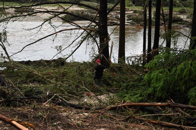 A man helps search for missing people near Camp Mystic, the site of where at least 20 girls went missing after flash flooding in Hunt, Texas, on July 5, 2025. Rescuers were on Saturday searching for more than 20 girls missing from a riverside summer camp in the US state of Texas, after torrential rains caused devastating flooding that killed at least 27 people -- with more rain on the way. "So far, we've evacuated over 850 uninjured people, eight injured people and have recovered 27 deceased fatalities at this time. Of these 27, 18 are adults, nine are children," said Kerr Country Sheriff Larry Leitha on July 5. (Photo by RONALDO SCHEMIDT / AFP)