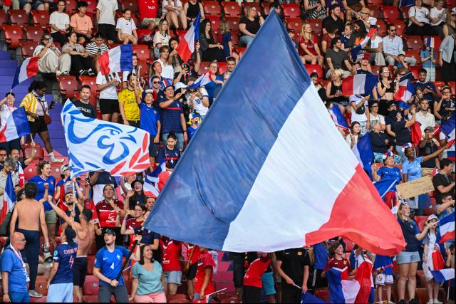 TOPSHOT - Fans of France wave a national flag as they cheer on their team ahead of the UEFA Women's Euro 2025 Group D football match between France and England at the Letzigrund Stadium in Zurich, on July 5, 2025. (Photo by SEBASTIEN BOZON / AFP)