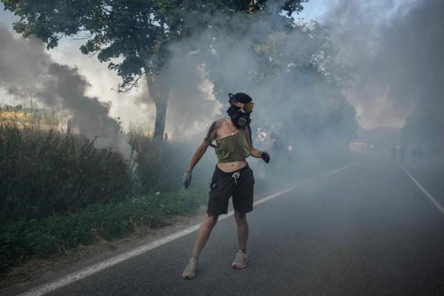 A protester reacts to teargas as they clash with police during a demonstration dubbed "Turbo-Teuf" against the A69 motorway project, in Morens-Scopont, southern France, on July 5, 2025. Environmental groups are holding a protest in the Tarn deparment against the construction of the Toulouse-Castres A69 motorway, despite the gathering's ban by authorities. (Photo by Ed JONES / AFP)