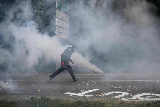 A protester reacts to teargas as they clash with police during a demonstration dubbed "Turbo-Teuf" against the A69 motorway project, in Morens-Scopont, southern France, on July 5, 2025. Environmental groups are holding a protest in the Tarn deparment against the construction of the Toulouse-Castres A69 motorway, despite the gathering's ban by authorities. (Photo by Ed JONES / AFP)