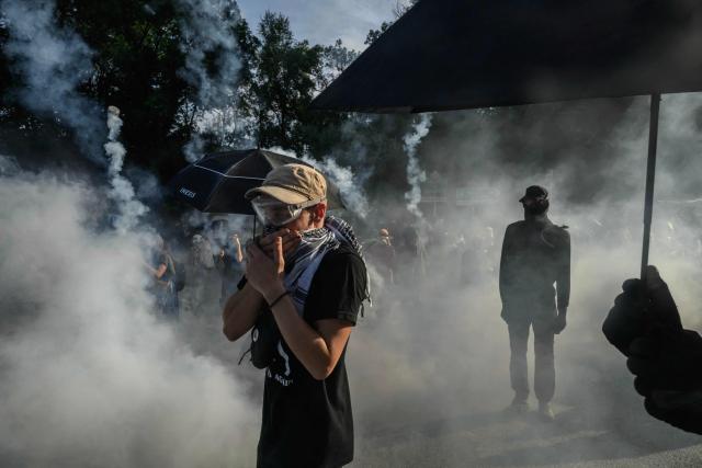 A protester reacts to teargas as they clash with police during a demonstration dubbed "Turbo-Teuf" against the A69 motorway project, in Morens-Scopont, southern France, on July 5, 2025. Environmental groups are holding a protest in the Tarn deparment against the construction of the Toulouse-Castres A69 motorway, despite the gathering's ban by authorities. (Photo by Ed JONES / AFP)