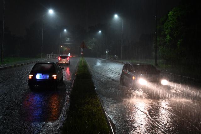 Commuters make their way through a flooded street during heavy rainfall in Islamabad on July 5, 2025. (Photo by Aamir QURESHI / AFP)