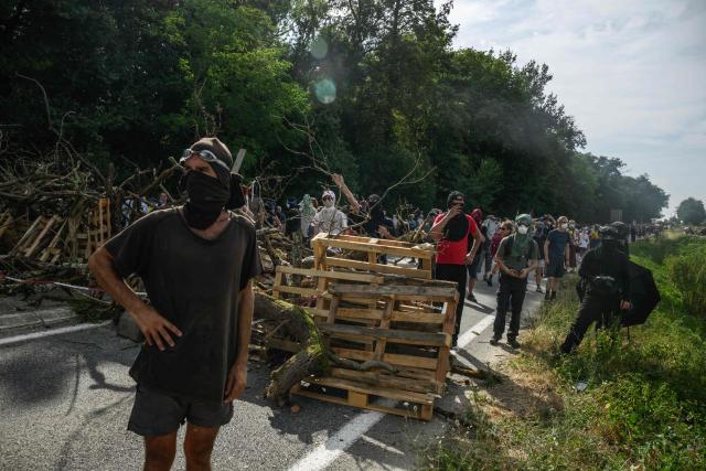Protesters gather behind a barricade on the national road next to the A69 during a demonstration dubbed "Turbo-Teuf" against the A69 motorway project, in Morens-Scopont, southern France, on July 5, 2025. Environmental groups are holding a protest in the Tarn deparment against the construction of the Toulouse-Castres A69 motorway, despite the gathering's ban by authorities. (Photo by Ed JONES / AFP)