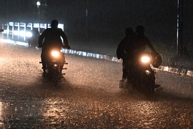 Commuters make their way on a street during heavy rainfall in Islamabad on July 6, 2025. (Photo by Aamir QURESHI / AFP)