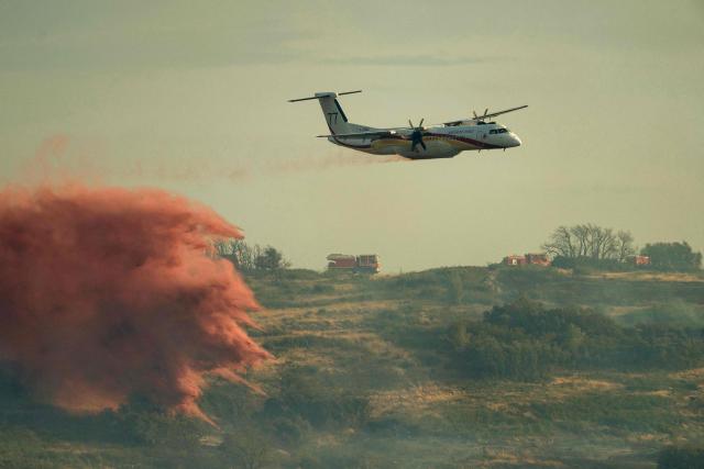 A DASH firefighting aircaft drops fire retardant during a wildfire near Fontcouverte, southwest France, on July 5, 2025. (Photo by IDRISS BIGOU-GILLES / AFP)