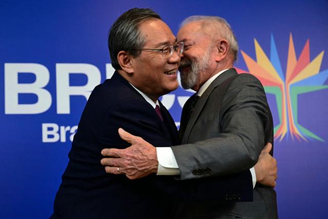 Brazil's President Luiz Inacio Lula da Silva (R) hugs China's Premier Li Qiang after a bilateral meeting ahead of the BRICS summit in Rio de Janeiro, Brazil, on July 5, 2025. BRICS leaders meeting in Rio de Janeiro from Sunday are expected to decry Donald Trump's hardline trade policies, but are struggling to bridge divides over crises roiling the Middle East. (Photo by Pablo PORCIUNCULA / AFP)