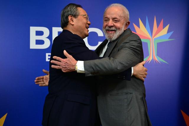 Brazil's President Luiz Inacio Lula da Silva (R) hugs China's Premier Li Qiang after a bilateral meeting ahead of the BRICS summit in Rio de Janeiro, Brazil, on July 5, 2025. BRICS leaders meeting in Rio de Janeiro from Sunday are expected to decry Donald Trump's hardline trade policies, but are struggling to bridge divides over crises roiling the Middle East. (Photo by Pablo PORCIUNCULA / AFP)