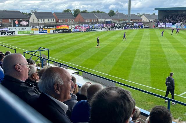 Crowds look on as a football match takes place in Lurgan, Northern Ireland on July 6, 2025. A European football tie cancelled due to Cold War-era tensions was finally completed in Northern Ireland on July 6, 2025, 65 years on from its original schedule in 1960. Glenavon FC hosted FC Erzgebirge Aue known as Wismut Karl-Marx-Stadt during the communist era, in Lurgan 25 miles (40 kilometres) west of Belfast. (Photo by Peter MURPHY / AFP)