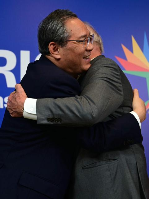 Brazil's President Luiz Inacio Lula da Silva (R) hugs China's Premier Li Qiang after a bilateral meeting ahead of the BRICS summit in Rio de Janeiro, Brazil, on July 5, 2025. BRICS leaders meeting in Rio de Janeiro from Sunday are expected to decry Donald Trump's hardline trade policies, but are struggling to bridge divides over crises roiling the Middle East. (Photo by Pablo PORCIUNCULA / AFP)