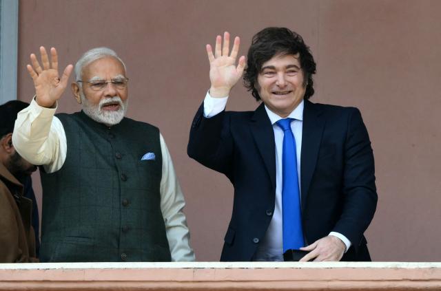 India's Prime Minister Narendra Modi (L) and Argentina's President Javier Milei wave on the balcony of the Casa Rosada government palace after a meeting in Buenos Aires, on July 5, 2025. Narendra Modi is visiting Argentina before heading to Brazil to attend the BRICS Summit in Rio de Janeiro. (Photo by Luis ROBAYO / AFP)
