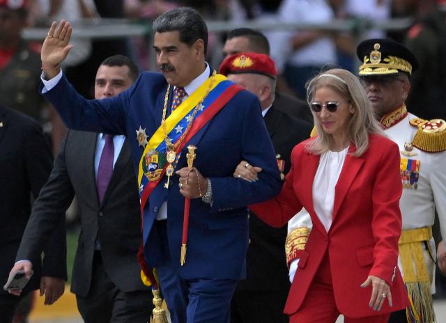 Venezuela's President Nicolas Maduro (C) waves next to First Lady Cilia Flores during celebrations for the Independence Day, in Caracas on July 5, 2025. (Photo by Juan BARRETO / AFP)