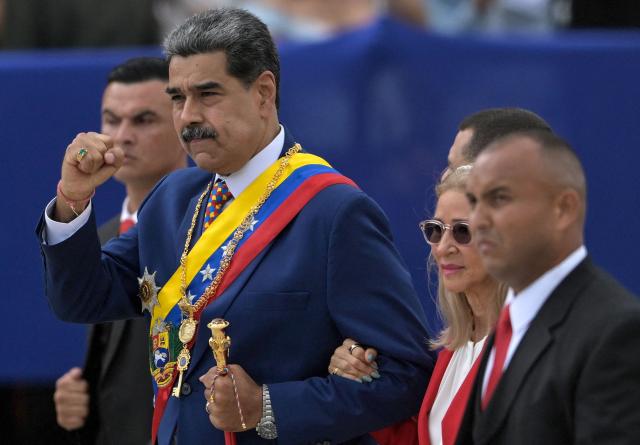 Venezuela's President Nicolas Maduro (C) First Lady Cilia Flores, walk during celebrations for the Independence Day, in Caracas on July 5, 2025. (Photo by Juan BARRETO / AFP)