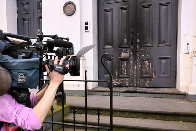 A camera crew film the burnt front entrance of the East Melbourne Synagogue in Melbourne on July 6, 2025. A man suspected of setting fire to an Australian synagogue as worshippers ate dinner inside has been arrested and charged, police said on July 6. (Photo by William WEST / AFP)