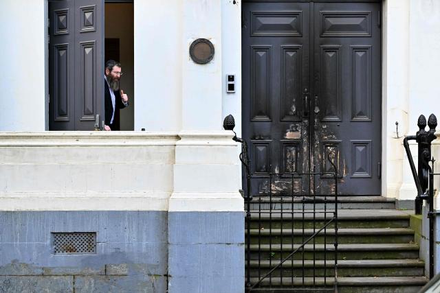 Rabbi Dovid Gutnick speaks to the media next to the burnt front entrance of the East Melbourne Synagogue in Melbourne on July 6, 2025. A man suspected of setting fire to an Australian synagogue as worshippers ate dinner inside has been arrested and charged, police said on July 6. (Photo by William WEST / AFP)