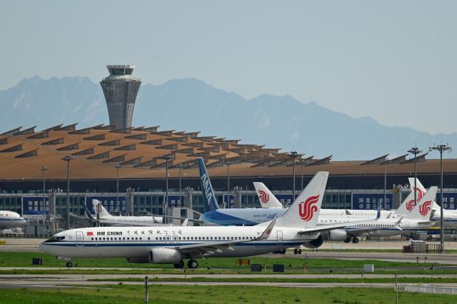 An Air China Boeing 737-800 (front) plane waits to take off at Beijing International airport on July 6, 2025. (Photo by WANG Zhao / AFP)