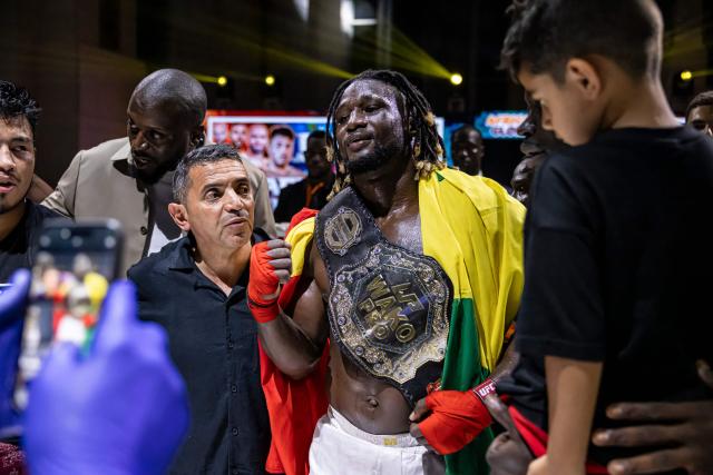 Senegalese kickboxer and World Champion Mouhamed Tafsir Ba (C) celebrates after winning against Swiss kickboxer Eric Brito (unseen) during their fight for the World Association of Kickboxing Organizations (WAKO) pro Intercontinental Belt in the 86kg category at the Grand Theater in Dakar, on July 6, 2025. (Photo by PATRICK MEINHARDT / AFP)