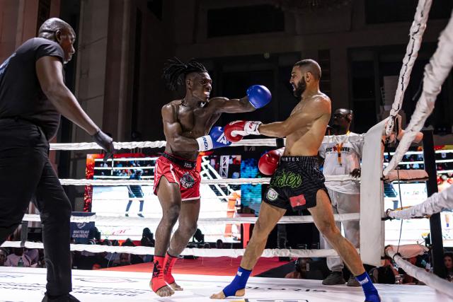 Moroccan kickboxer Ahmed Moudatir (R) and Ivorian kickboxer Francois Mozou (L) compete during their fight for the World Association of Kickboxing Organizations (WAKO) pro Continental Belt in the 67kg category at the Grand Theater in Dakar on July 5, 2025. (Photo by PATRICK MEINHARDT / AFP)