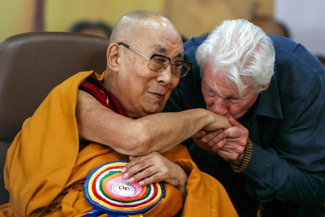 US actor Richard Gere (R) kisses Tibetan spiritual leader the Dalai Lama's hand during a prayer ceremony celebrating his 90th birth anniversary at the Main Tibetan Temple in McLeod Ganj, near Dharamsala, on July 6, 2025. Calling himself a "simple Buddhist monk" who usually didn't celebrate birthdays, the Dalai Lama marked his 90th on July 6 by praying for peace after China insisted it would have the final say on who succeeded the Tibetan spiritual leader. (Photo by Niharika KULKARNI / AFP)