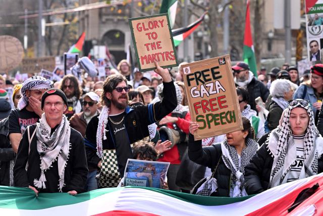 People hold placards and wave flags during a pro-Palestinian march through the streets of Melbourne on July 6, 2025, amid the ongoing conflict between Israel and the Palestinian Hamas militant group. (Photo by William WEST / AFP)