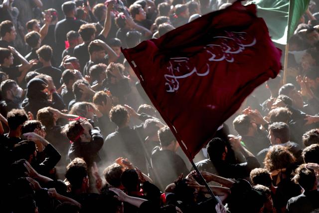 Iraqi Shiite Muslims beat their heads as they take part in a mourning ritual to mark Ashura, a 10-day period commemorating the seventh century killing of Prophet Mohammed's grandson Imam Hussein, in Nasiriyah, in Iraq's southern Dhi Qar province early on July 6, 2025. (Photo by Asaad NIAZI / AFP)