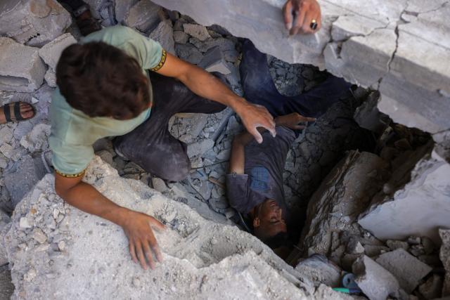 Palestinians search for survivors in the rubble of a building in the Sheikh Radwan neighbourhood in Gaza City, in the central Gaza Strip that was targeted in an Israeli strike on July 6, 2025. An Israeli delegation was expected in Doha on July 6 for talks on a Gaza truce and hostage release deal, after Palestinian group Hamas said it was ready to start negotiations "immediately". (Photo by Bashar TALEB / AFP)