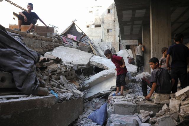 Palestinian children look on as people seach for survivors in the rubble of a building in the Sheikh Radwan neighbourhood in Gaza City, in the central Gaza Strip that was targeted in an Israeli strike on July 6, 2025. An Israeli delegation was expected in Doha on July 6 for talks on a Gaza truce and hostage release deal, after Palestinian group Hamas said it was ready to start negotiations "immediately". (Photo by Bashar TALEB / AFP)