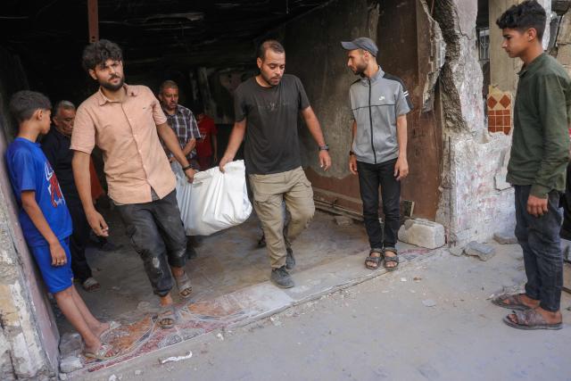 People carry the body of a Palestinian killed in an Israeli strike that targeted a building in the Sheikh Radwan neighbourhood in Gaza City, in the central Gaza Strip on July 6, 2025. An Israeli delegation was expected in Doha on July 6 for talks on a Gaza truce and hostage release deal, after Palestinian group Hamas said it was ready to start negotiations "immediately". (Photo by Bashar TALEB / AFP)