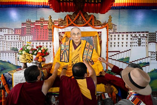 Exiled Tibetan monks perform rituals with a cut-out of their spiritual leader the Dalai Lama, to celebrate his 90th birthday at a Tibetan refugee camp in the Jawalakhel area of Lalitpur, on the outskirts of Kathmandu on July 6, 2025. Calling himself a "simple Buddhist monk" who usually doesn't celebrate birthdays, the Dalai Lama marked his 90th on July 6, by praying for peace after China insisted it would have the final say on who succeeded the Tibetan spiritual leader. (Photo by Prakash MATHEMA / AFP)