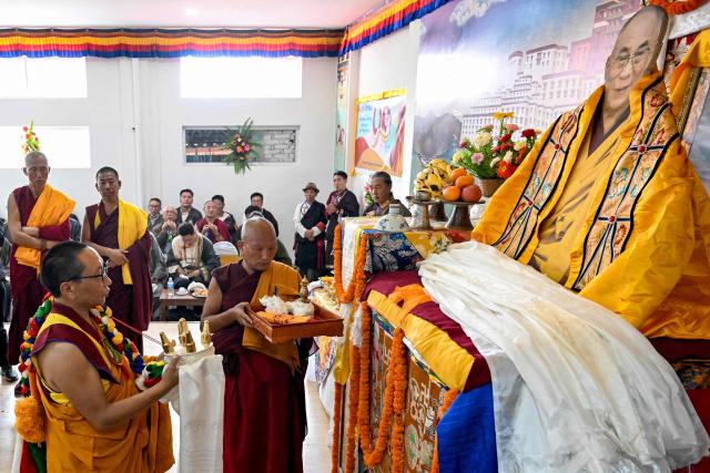 Exiled Tibetan monks perform rituals with a cut-out of their spiritual leader the Dalai Lama, to celebrate his 90th birthday at a Tibetan refugee camp in the Jawalakhel area of Lalitpur, on the outskirts of Kathmandu on July 6, 2025. Calling himself a "simple Buddhist monk" who usually doesn't celebrate birthdays, the Dalai Lama marked his 90th on July 6, by praying for peace after China insisted it would have the final say on who succeeded the Tibetan spiritual leader. (Photo by Prakash MATHEMA / AFP)