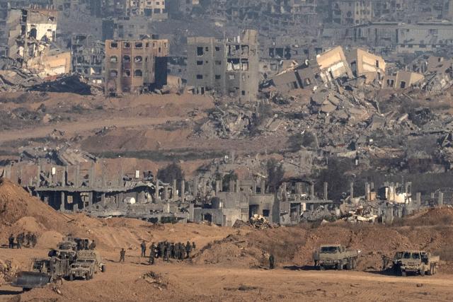 This picture taken from a position near Israel's border with the Gaza Strip, shows Israeli soldiers and vehicles inside the the besieged territory on July 6, 2025. An Israeli delegation was expected in Doha on July 6 for talks on a Gaza truce and hostage release deal, ahead of a visit by Prime Minister Benjamin Netanyahu to the White House. (Photo by Maya Levin / AFP)