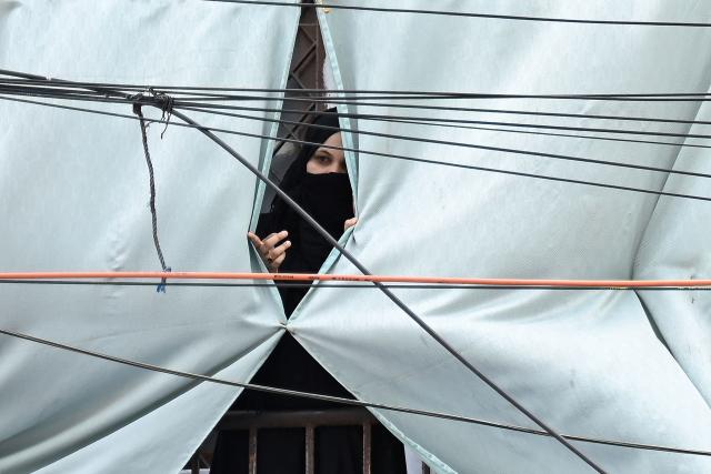 A woman watch a religious procession marking Ashura, the tenth day of the Islamic holy month of Muharram, in Chennai on July 6, 2025. (Photo by R.Satish BABU / AFP)