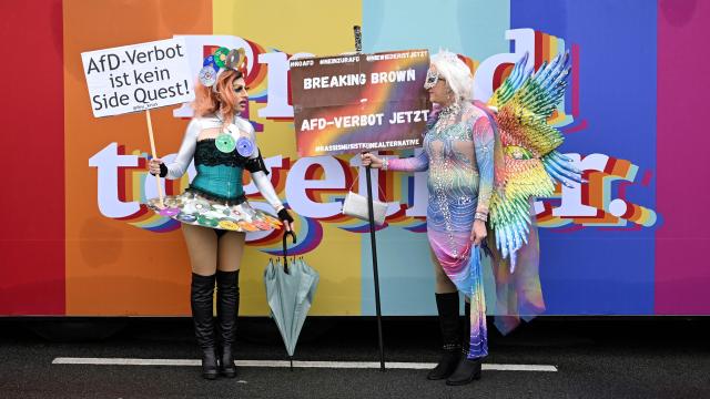 Revellers protesting with placards against far-right Alternative for Germany (AfD) party pose for photos before taking part in the Christopher Street Day (CSD) demonstration in Cologne, western Germany on July 6, 2025. The motto of this year's demonstration is "For queer rights. Many. Strong together." (Photo by INA FASSBENDER / AFP)