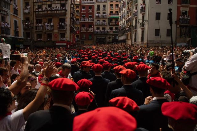 The "Pamplonesa" municipal music band performs during the "Chupinazo" (rocket launch) marking the official start of the San Fermin Festival in Plaza Consistorial outside the Town Hall of Pamplona in northern Spain on July 6, 2025. Thousands of people every year attend the week-long festival and its famous 'encierros' (bull runs) in which six bulls are released at 8:00 a.m. evey day starting July 7, to run from their corral to the bullring through the narrow streets of the old town over an 850 meters (yard) course while runners ahead of them try to stay close to the bulls without falling over or being gored. (Photo by JORGE GUERRERO / AFP)