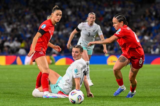 Switzerland's defender #18 Viola Calligaris (L) and teammate Switzerland's forward #06 Geraldine Reuteler, fight for the ball against Iceland's midfielder #07 Karolina Lea Vilhjalmsdottir (C) during the UEFA Women's Euro 2025 Group A football match between Switzerland and Iceland at the Wankdorf stadium in Bern, on July 6, 2025. (Photo by SEBASTIEN BOZON / AFP)