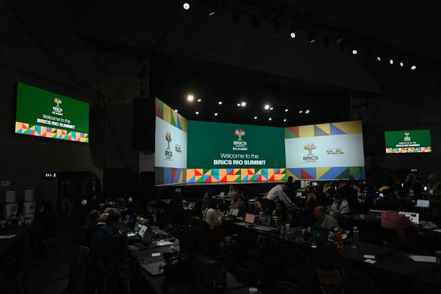 Journalists work at the press room during the BRICS summit in Rio de Janeiro, Brazil, on July 6, 2025. BRICS leaders descended on sunny Rio de Janeiro Sunday, but issued a dark warning that US President Donald Trump's "indiscriminate" import tariffs risk hurting the global economy. (Photo by Mauro PIMENTEL / AFP)