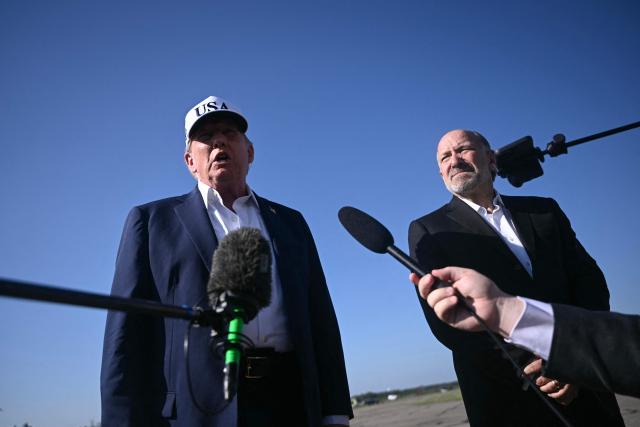 (L/R) US President Donald Trump and Secretary of Commerce Howard Lutnick speak to reporters before boarding Air Force One at Morristown Municipal Airport in Morristown, New Jersey, on July 6, 2025, en route to Washington after spending the weekend at his residence in Bedminster, New Jersey. (Photo by Brendan SMIALOWSKI / AFP)