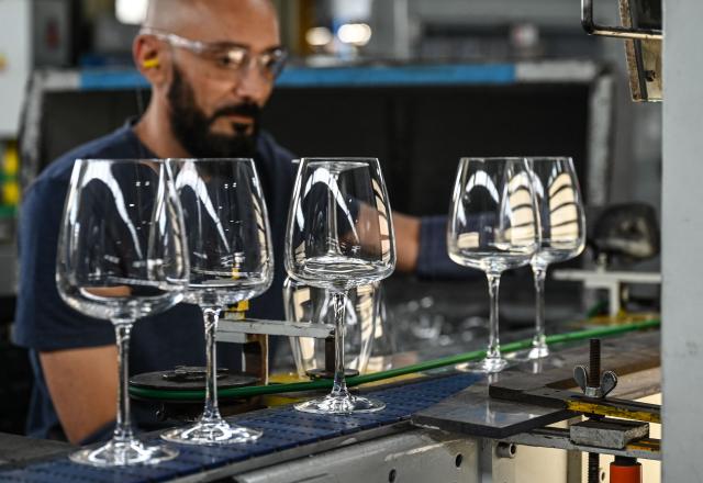 (FILES) An employee checks stemmed glasses on a production line at the factory of the Arc International company, specialised in the design and the manufacture of table glassware, in Arques on September 13, 2022. In its industrial cathedral in northern France, glassmaker Arc International is relying on restructuring and new shareholders to overcome its difficulties, while also seeking to reduce its carbon emissions. (Photo by DENIS CHARLET / AFP)
