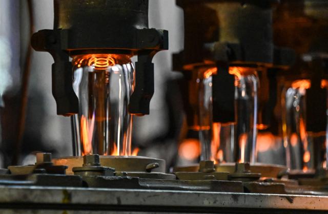 (FILES) Stemmed glasses are heated at the factory of the Arc International company, specialised in the design and the manufacture of table glassware, in Arques on September 13, 2022. In its industrial cathedral in northern France, glassmaker Arc International is relying on restructuring and new shareholders to overcome its difficulties, while also seeking to reduce its carbon emissions. (Photo by Denis Charlet / AFP)
