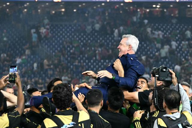 Mexico's players celebrate their victory by throwing Mexico's coach Javier Aguirre up in the air at the end of the Concacaf Gold Cup final football match between Mexico and USA at NRG Stadium in Houston, Texas on July 6, 2025. (Photo by Chandan Khanna / AFP)