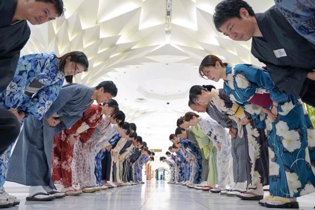 Sales clerks of the Nihonbashi Mitsukoshi department store clad in yukata, a Japanese unlined cotton summer kimono dress, greet customers in Tokyo on July 7, 2025. (Photo by Kazuhiro NOGI / AFP)