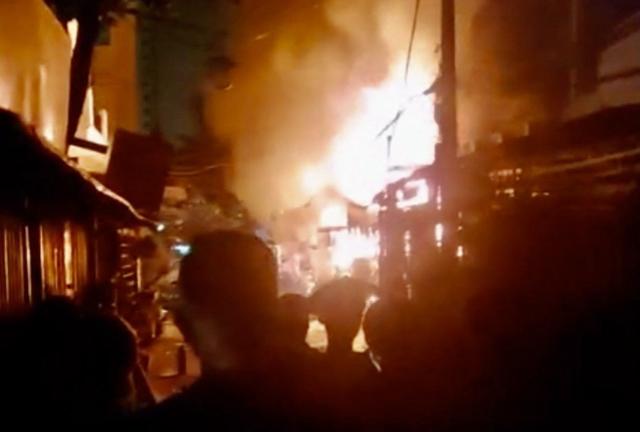 This photo released by the Vietnam News Agency (VNA) on July 7, 2025 shows people watching a fire at an apartment block in Ho Chi Minh City on July 6, 2025. A blaze that tore through an apartment block in Vietnam's southern business hub of Ho Chi Minh City killed eight people, including two children, local authorities said on July 7. (Photo by Vietnam News Agency / AFP)