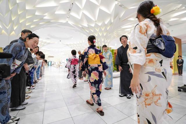 Sales clerks of the Nihonbashi Mitsukoshi department store clad in yukata, a Japanese unlined cotton summer kimono dress, greet customers in Tokyo on July 7, 2025. (Photo by Kazuhiro NOGI / AFP)