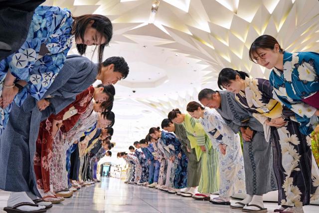 Sales clerks of the Nihonbashi Mitsukoshi department store clad in yukata, a Japanese unlined cotton summer kimono dress, greet customers in Tokyo on July 7, 2025. (Photo by Kazuhiro NOGI / AFP)